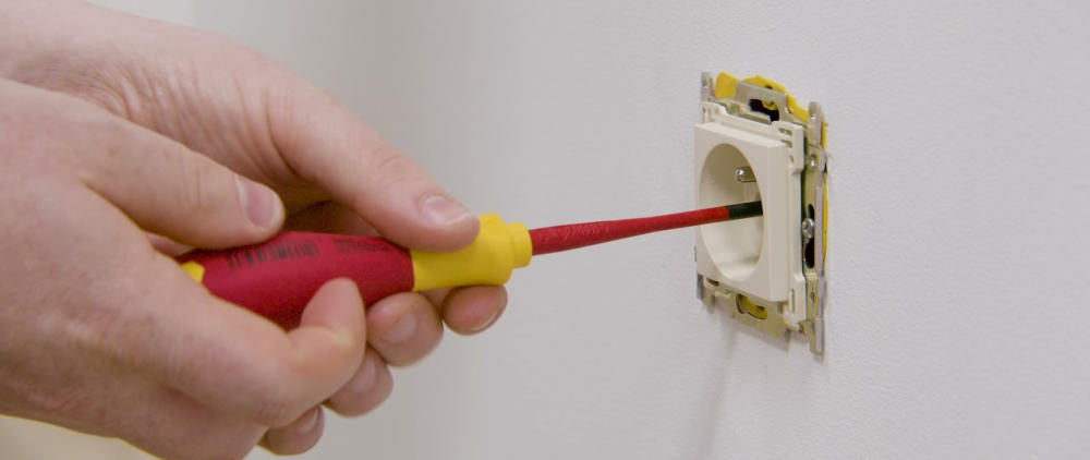 Herstelling van een stopcontact met geïsoleerde schroevendraaier